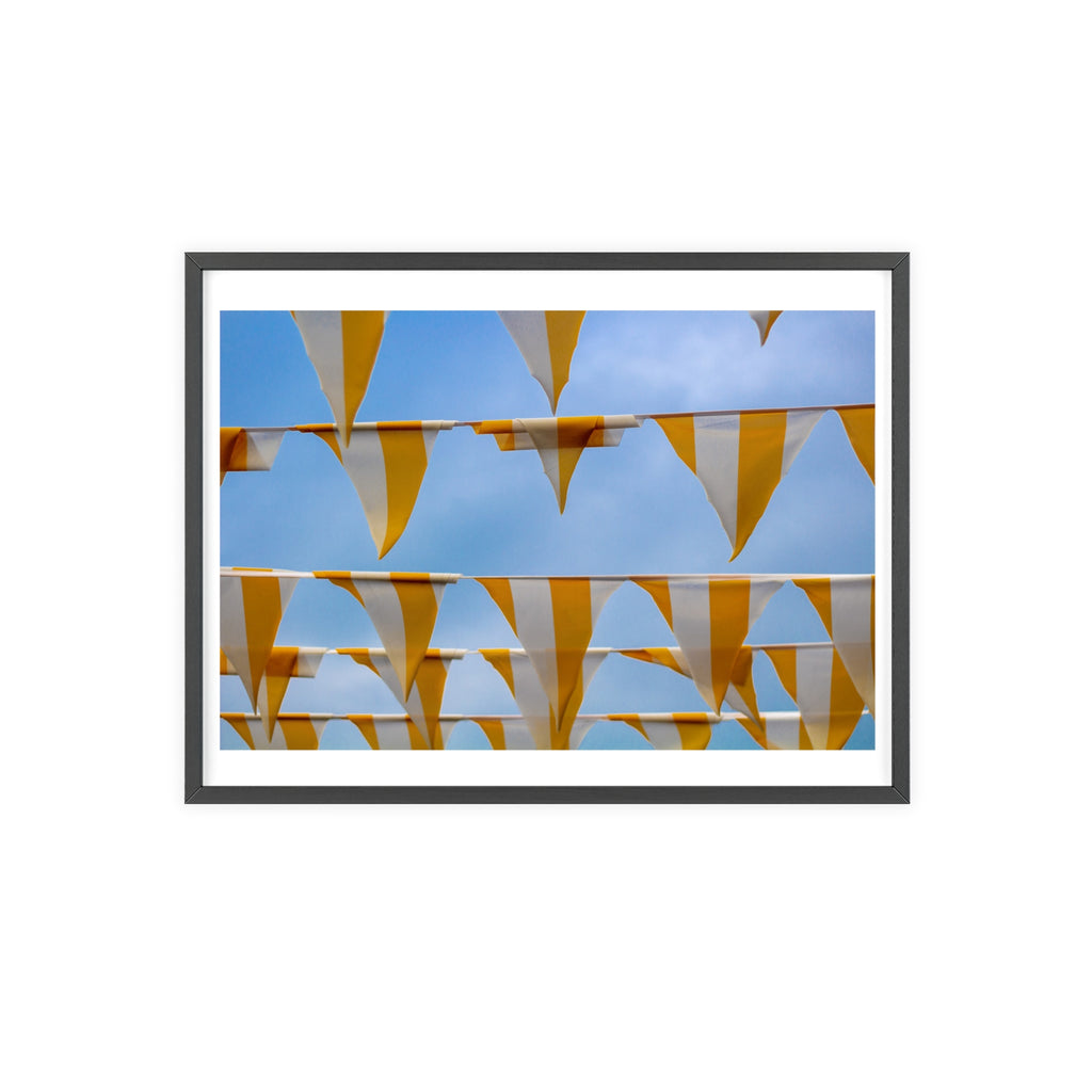 Framed artwork of yellow and white striped flags against a blue sky.