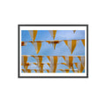 Framed artwork of yellow and white striped flags against a blue sky.