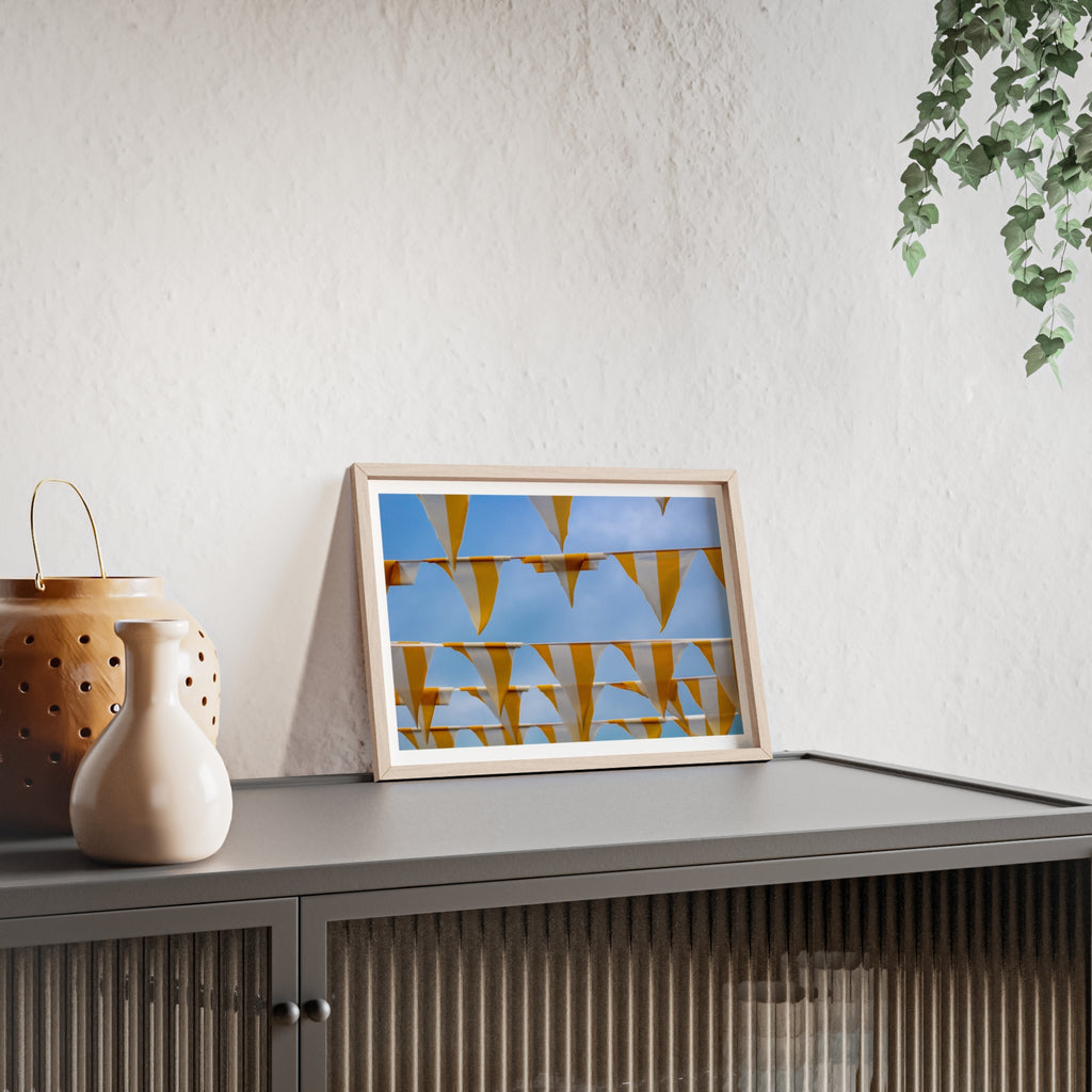 Framed artwork on a shelf with decorative items and a plant in the background