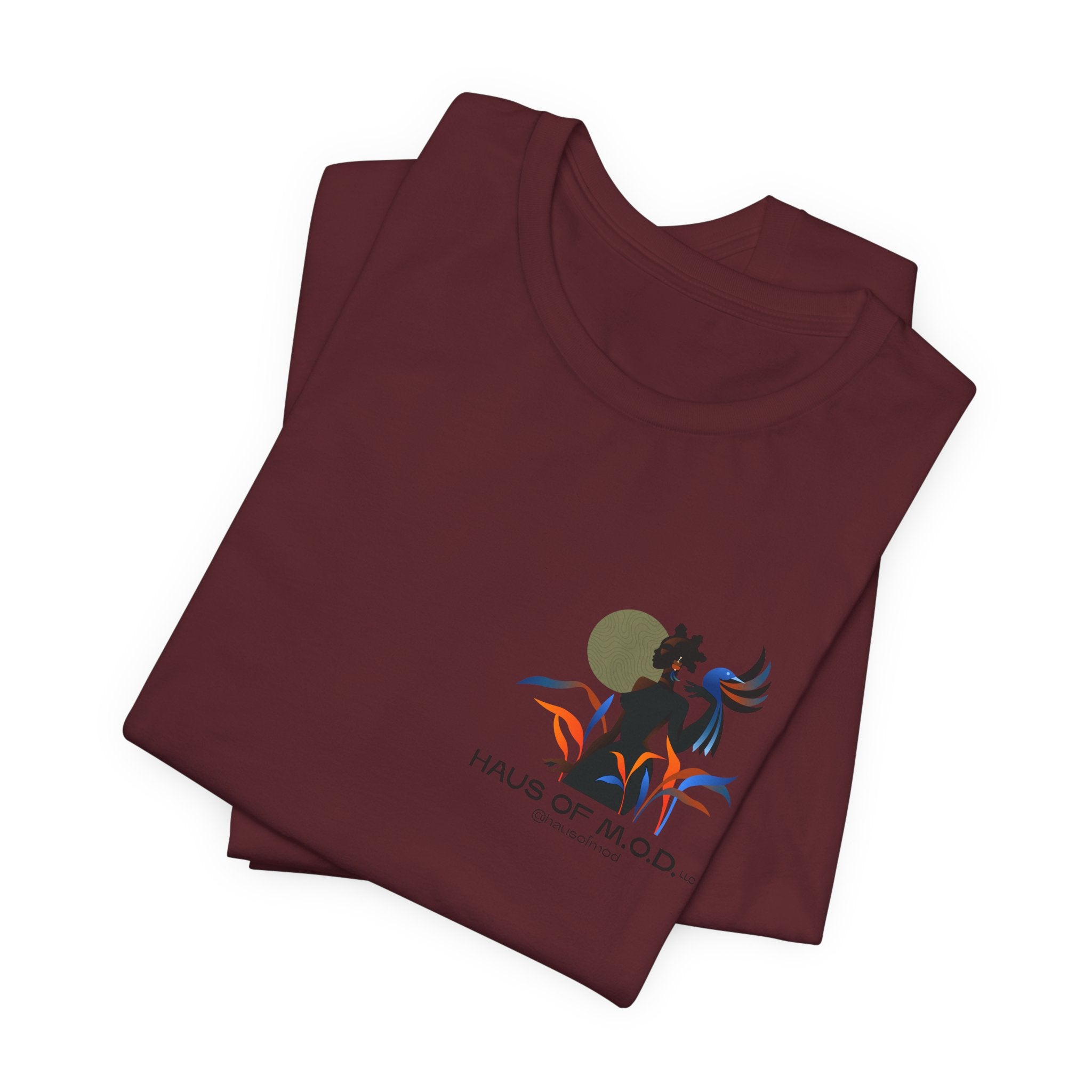 Folded maroon t-shirt with a colorful graphic design on a white background