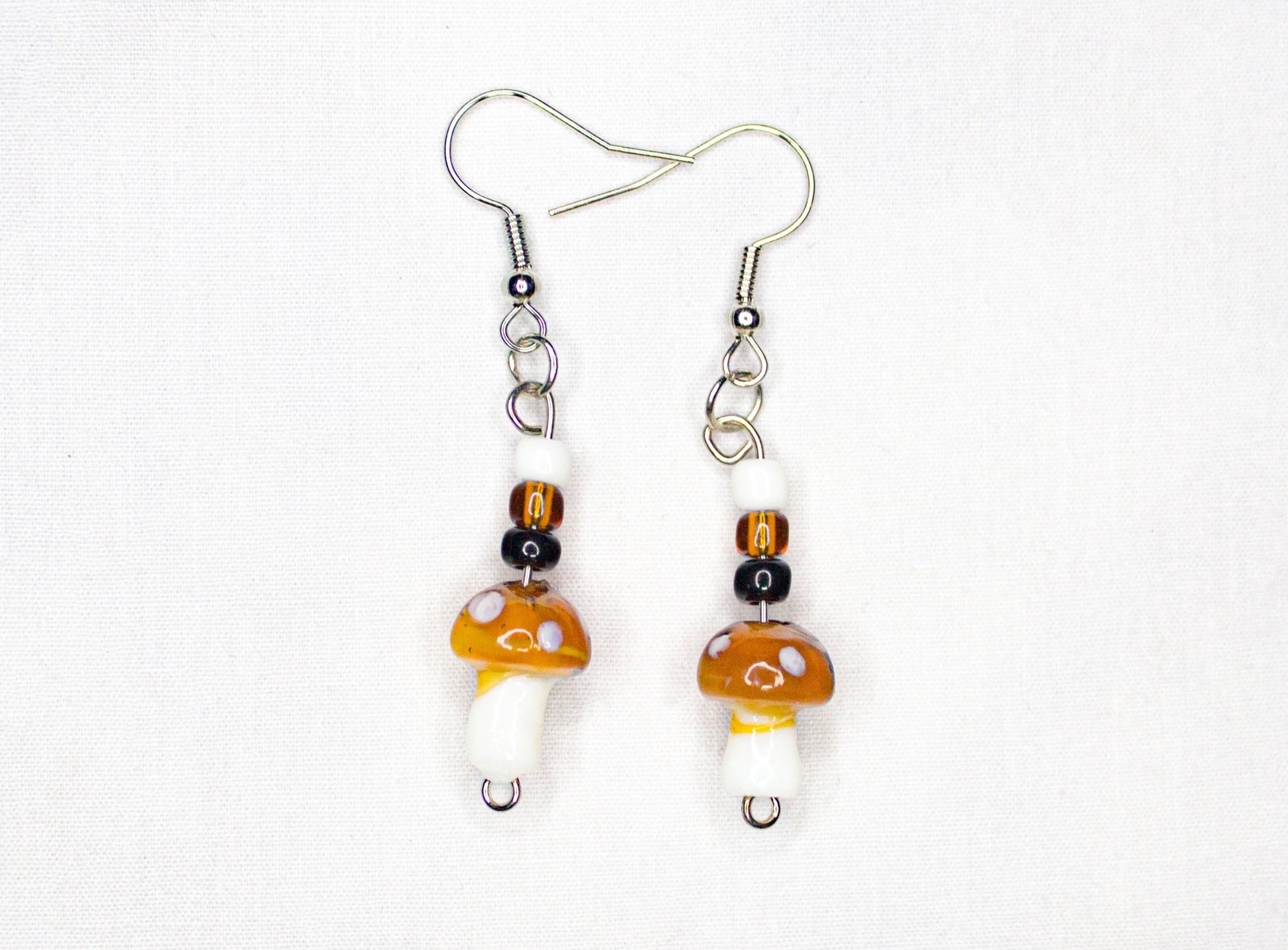 White, brown, and black mushroom earrings